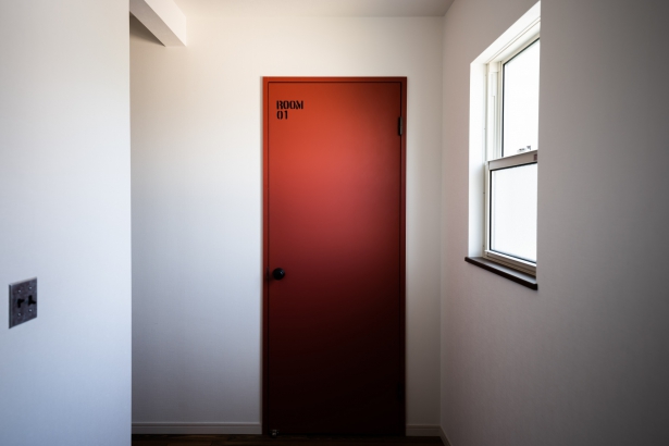 寝室のドアは落ち着いた赤でアクセントを